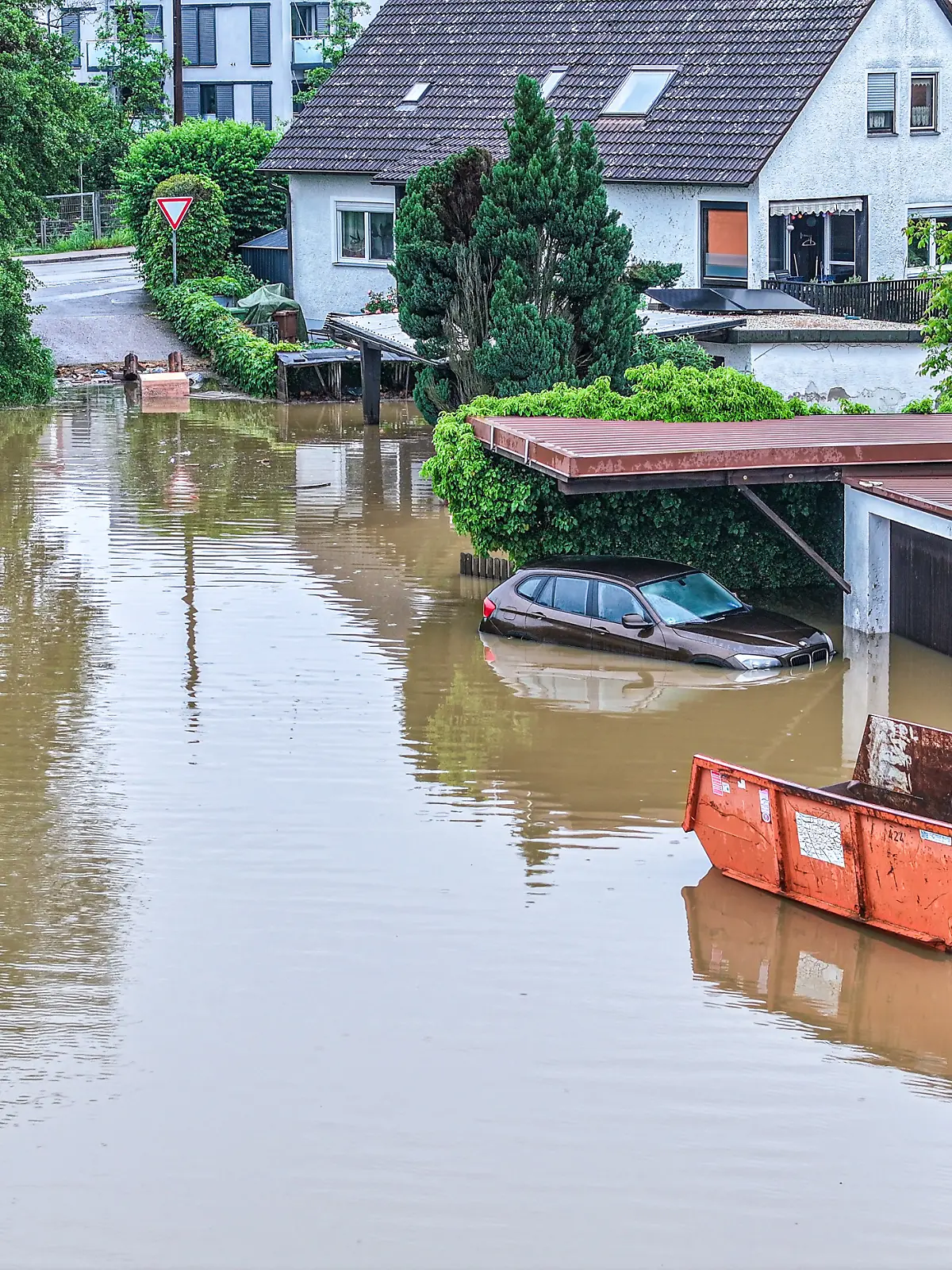 Auto und Haus stehen unter Wasser