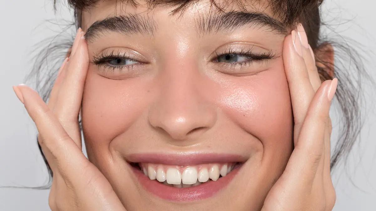 Close up studio shot of a beautiful woman with perfect skin, she touching her face