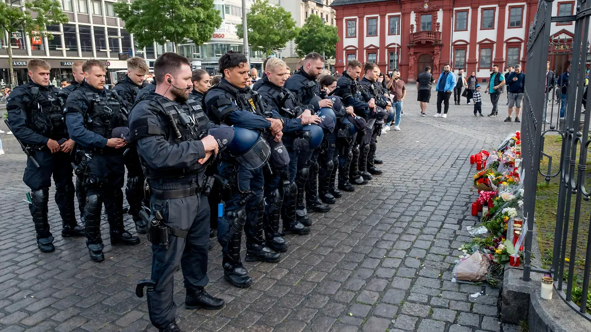 German police officers commemorate a colleague in Mannheim Germany, after learning that a police officer, who was stabbed two days ago there has died on Sunday, June 2, 2024. (AP Photo/Michael Probst)