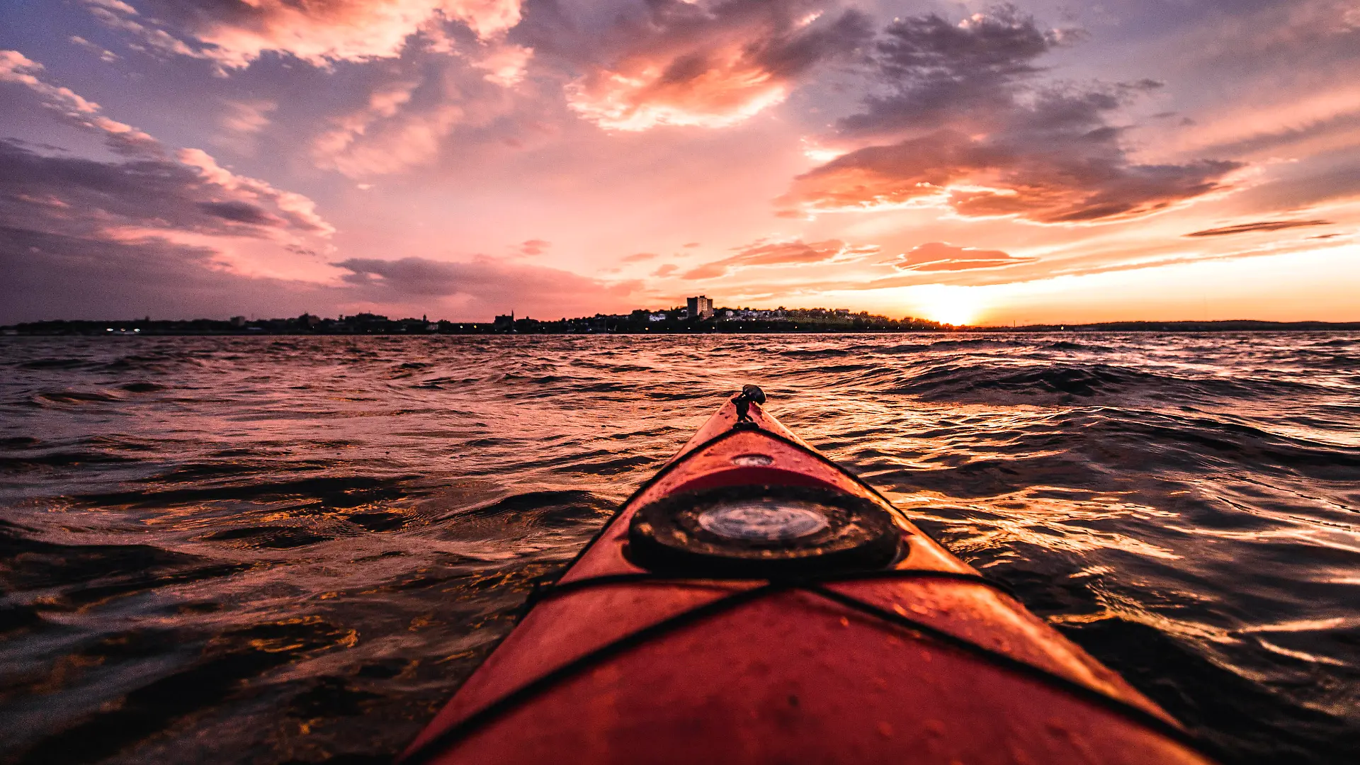 POV from red kayak during vibrant sunset in Portland harbor, Maine Portland, ME, United States PUBLICATIONxINxGERxSUIxAUTxONLY CR_SSNF200715B-449750-01