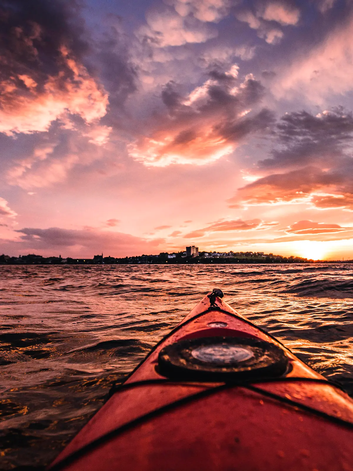 POV from red kayak during vibrant sunset in Portland harbor, Maine Portland, ME, United States PUBLICATIONxINxGERxSUIxAUTxONLY CR_SSNF200715B-449750-01