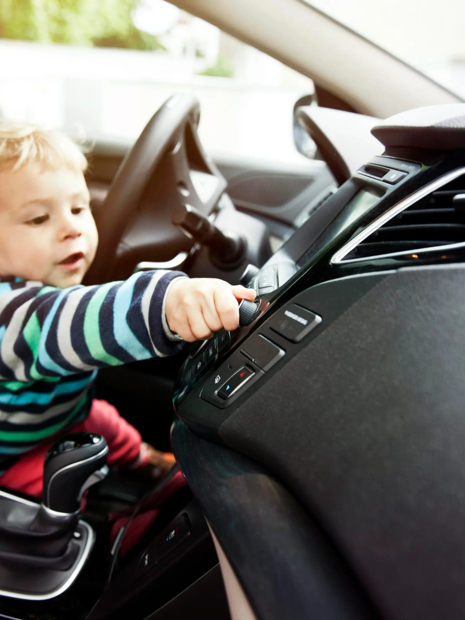 Germany, Bonn, Baby boy turning knob in car || Modellfreigabe vorhanden