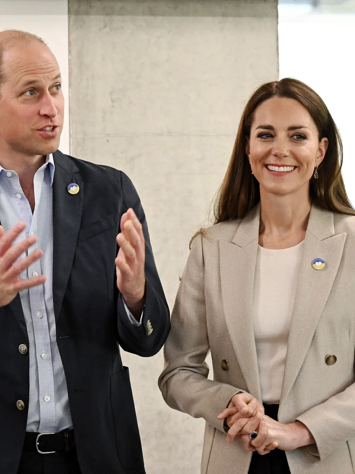21.04.2022, Großbritannien, London: Prinz William (l), Herzog von Cambridge, spricht anlässlich eines Besuchs in der Londoner Zentrale des DEC, während Kate (M), Herzogin von Cambridge, ihm dabei zuhört. Das Paar besucht die Zentrale um sich über die laufende Unterstützung in der Ukraine zu informieren. Foto: Jeff Spicer/PA Wire/dpa +++ dpa-Bildfunk +++