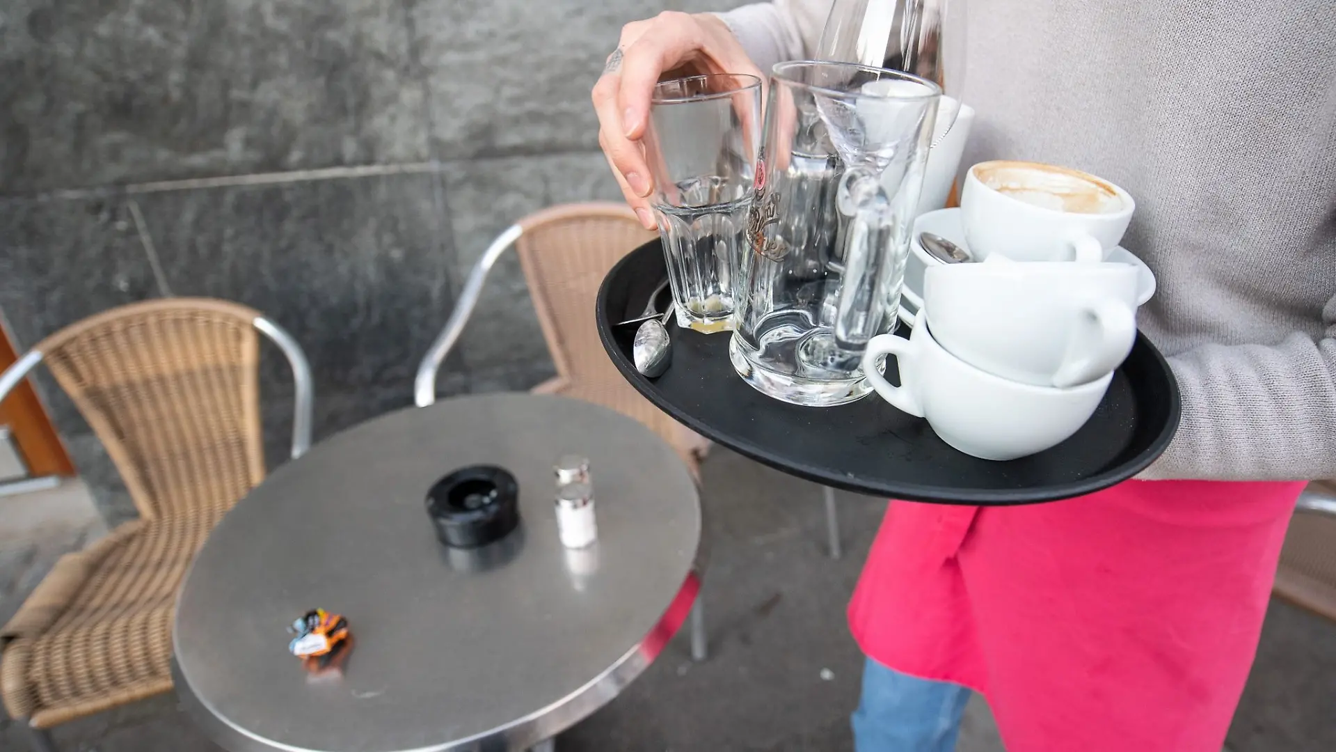 Ein Kellner räumt einen Tisch in einem Restaurant ab.