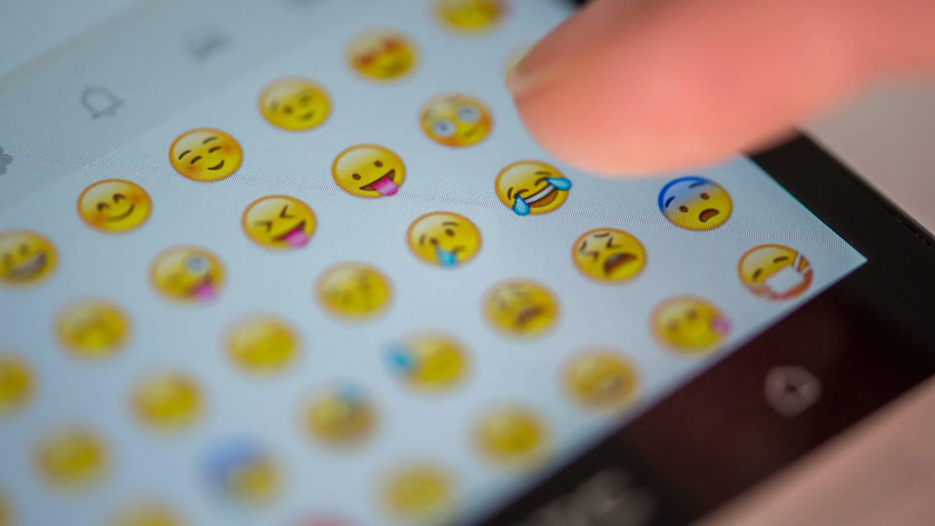 ILLUSTRATION - Eine Frau tippt am 24.08.2015 in München (Bayern) auf das Display eines Smartphones, auf dem zahlreiche Emojis in der Nachrichten-App "Whatsapp" zu sehen sind. Foto: Matthias Balk/dpa (zu dpa "Vom :-) zum Emoji" vom 24.08.2015) +++(c) dpa - Bildfunk+++