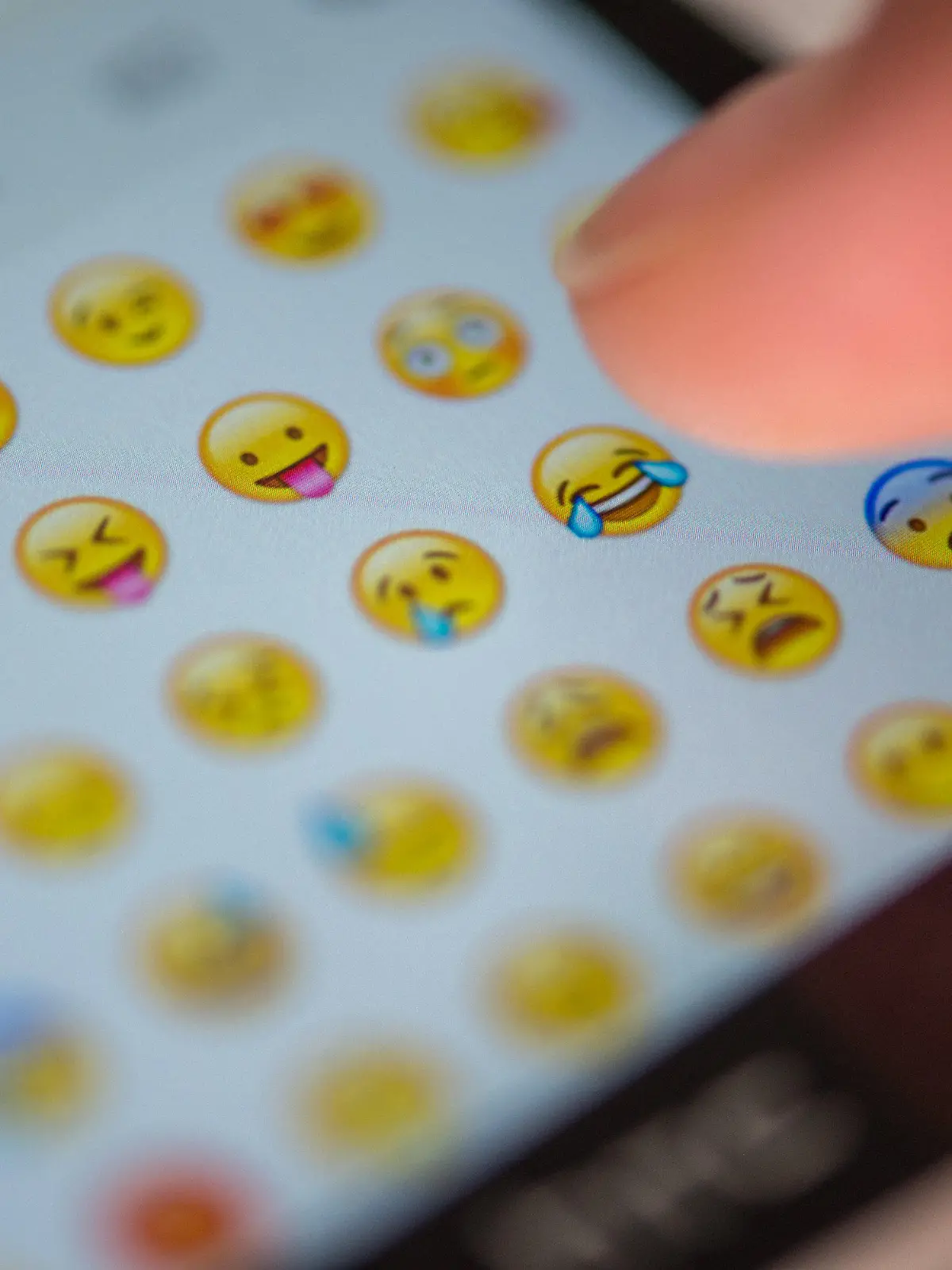 ILLUSTRATION - Eine Frau tippt am 24.08.2015 in München (Bayern) auf das Display eines Smartphones, auf dem zahlreiche Emojis in der Nachrichten-App "Whatsapp" zu sehen sind. Foto: Matthias Balk/dpa (zu dpa "Vom :-) zum Emoji" vom 24.08.2015) +++(c) dpa - Bildfunk+++