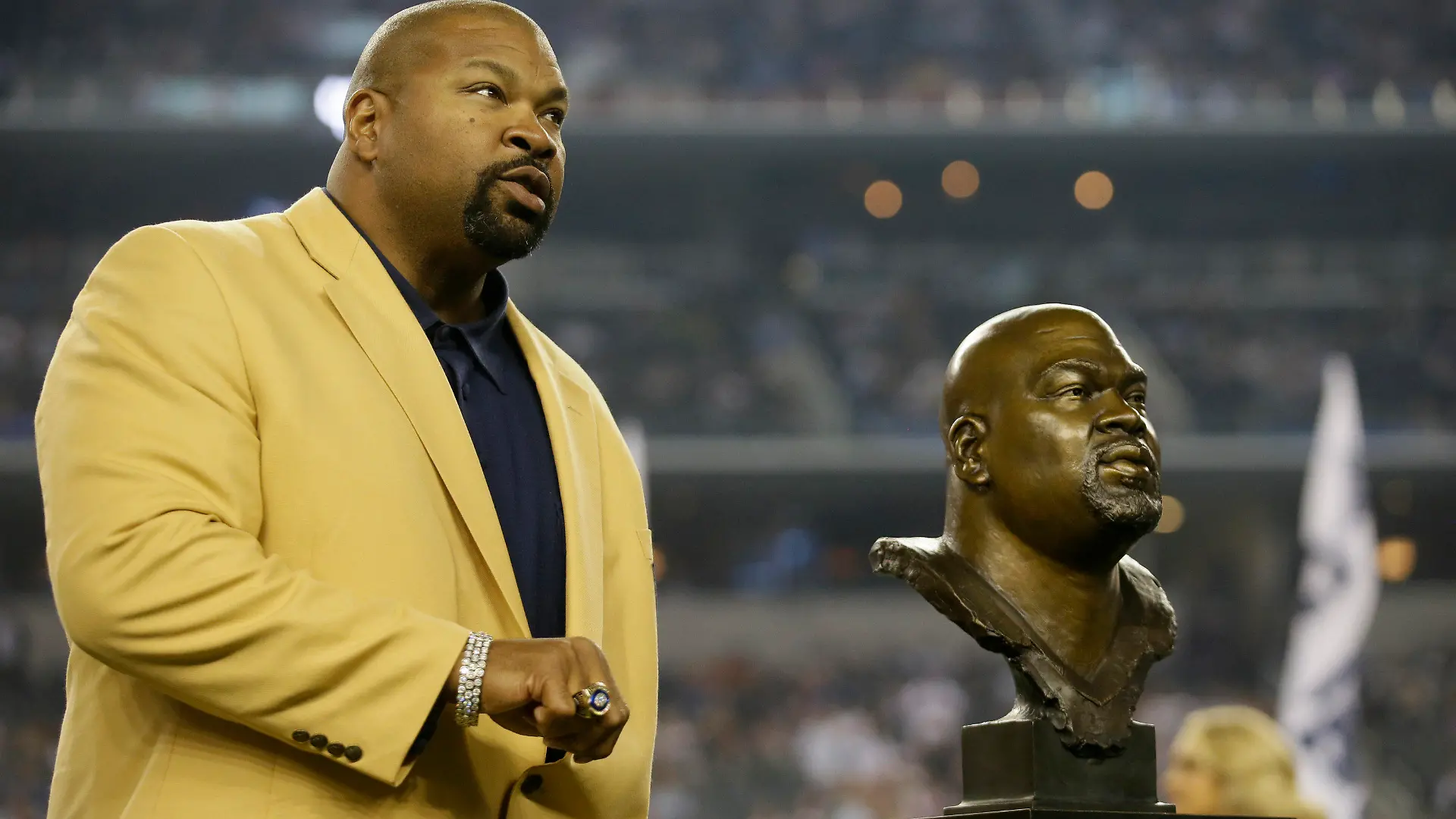 FILE - Dallas Cowboys Hall of Fame Inductee Larry Allen shows off his Hall of Fame ring at halftime of an NFL football game, Oct. 13, 2013, in Arlington, Texas. Allen, one of the most dominant offensive linemen in the NFL during a 12-year career spent mostly with the Dallas Cowboys, died suddenly on Sunday, June 2, 2024, while on vacation with his family in Mexico, the Cowboys said. He was 52. (AP Photo/Tim Sharp, File)
