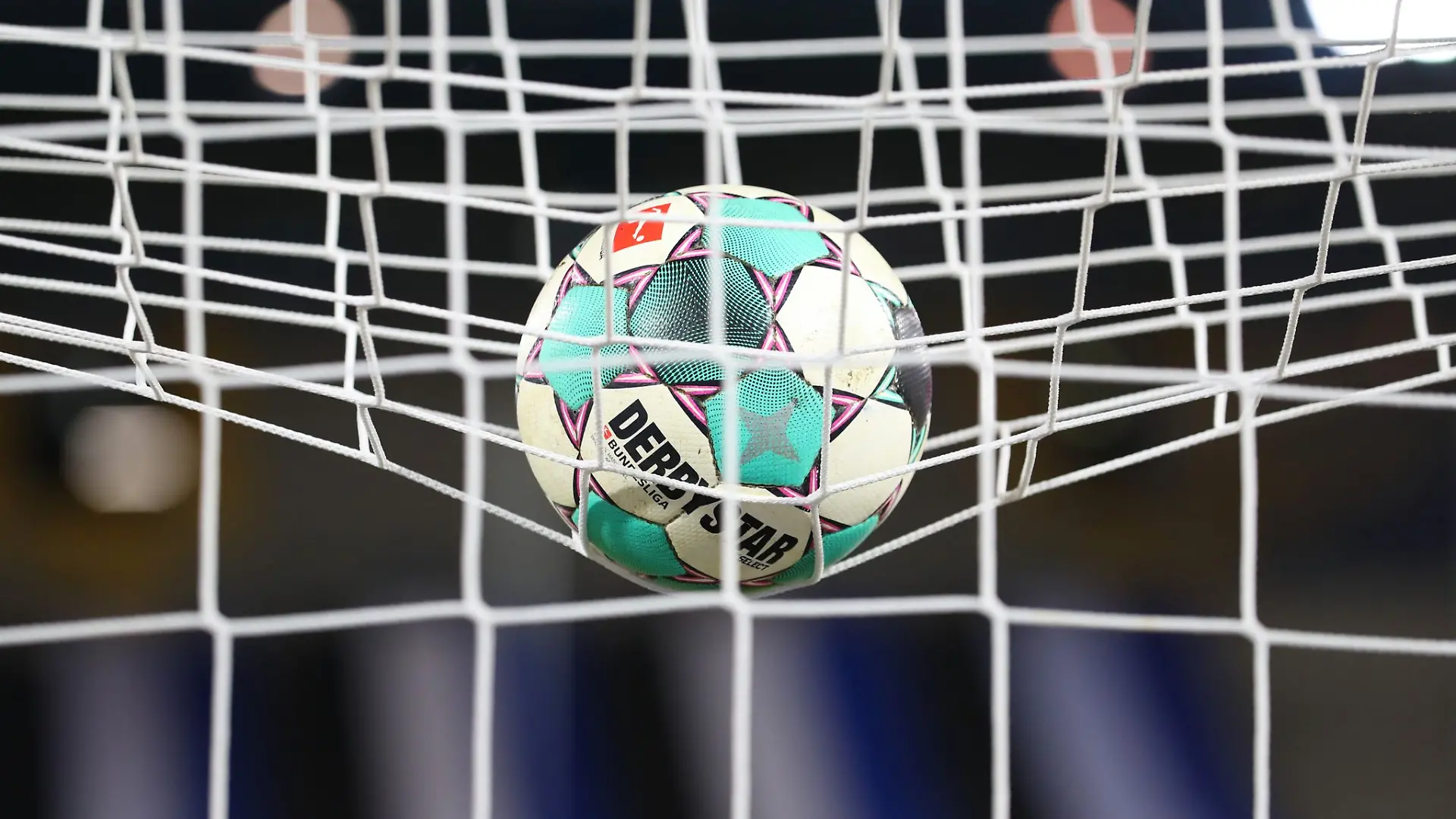 Ein Fußball liegt vor der Partie im Netz.