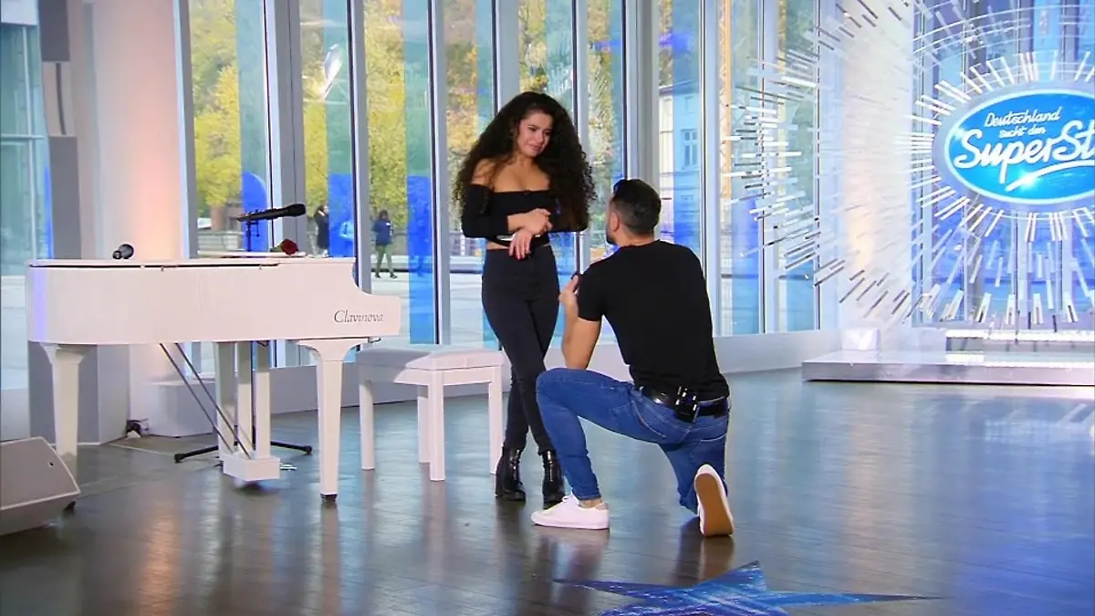 Jorgo kniet vor seiner Bana und macht ihr einen Antrag.