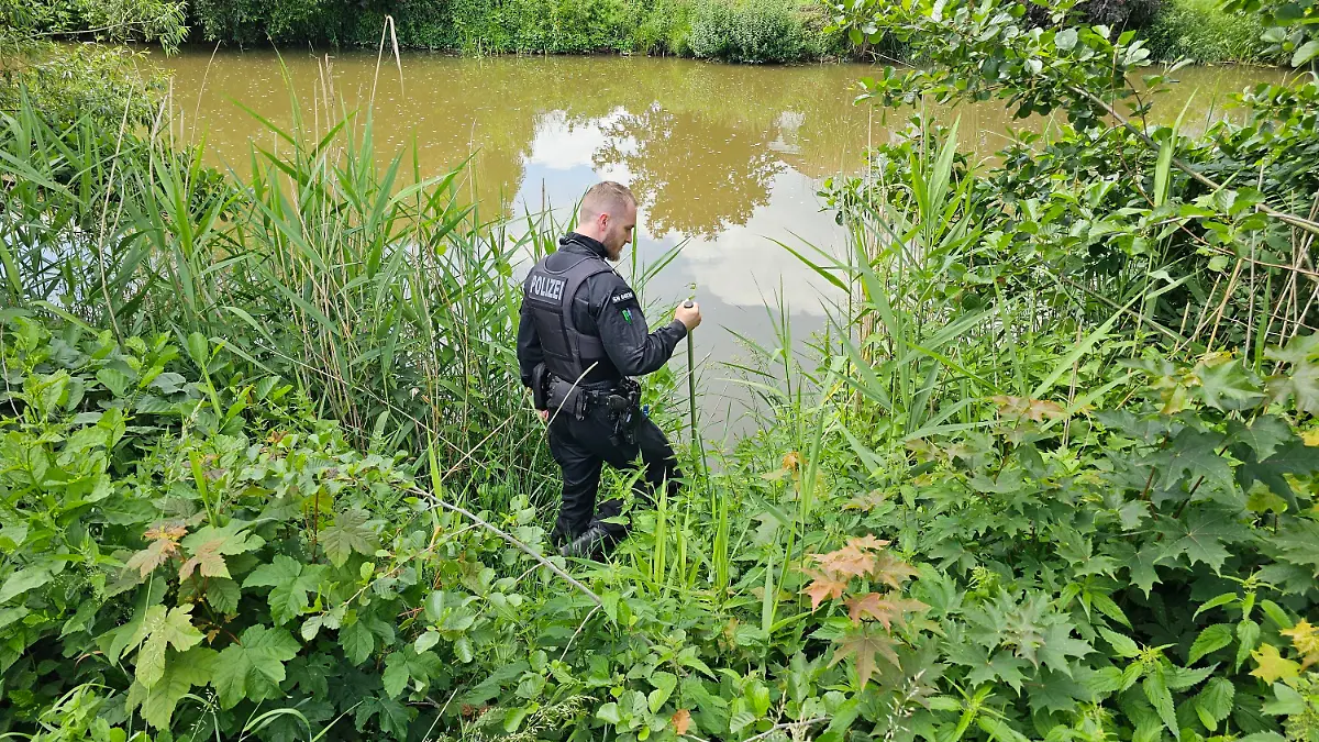 04.06.2024, Döbeln: Ein Polizist sucht an einem Gewässer in Döbeln nach einem neunjährigen Mädchen, das als vermisst gemeldet wurde. Neben dem Stadtgebiet stehen dabei auch Gewässer wie die Mulde und Teiche im Fokus, auch Taucher und Wasserschutzpolizei sind im Einsatz. (Zu dpa:«Suche nach vermisstem Mädchen in Döbeln - Auch Taucher im Einsatz») Foto: Tobias Junghannß/dpa-Zentralbild/dpa +++ dpa-Bildfunk +++