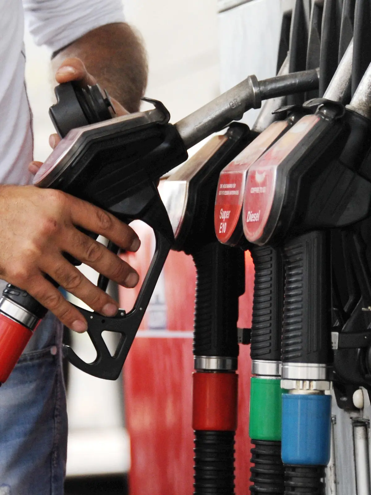 ARCHIV - Ein Mann greift am 31.08.2013 in München (Bayern) nach einer Zapfpistole an einer Tankstelle. Foto: Tobias Hase/dpa (zu dpa "Konjunkturstütze: Billiges Öl hilft Unternehmen und Verbrauchern" vom 14.11.2014) +++(c) dpa - Bildfunk+++