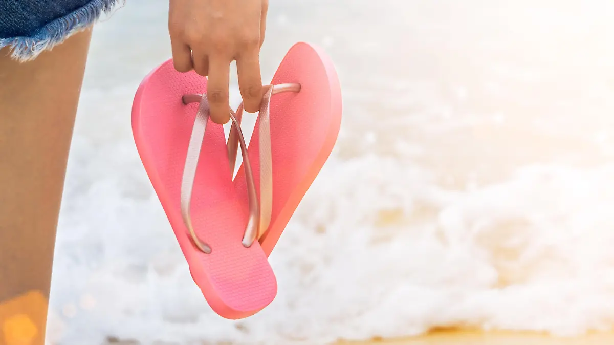Frau trägt Flip Flops am Strand