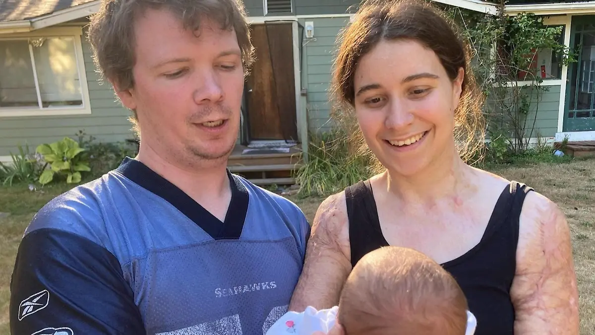 Ein Paar mit einem Baby auf dem Arm.