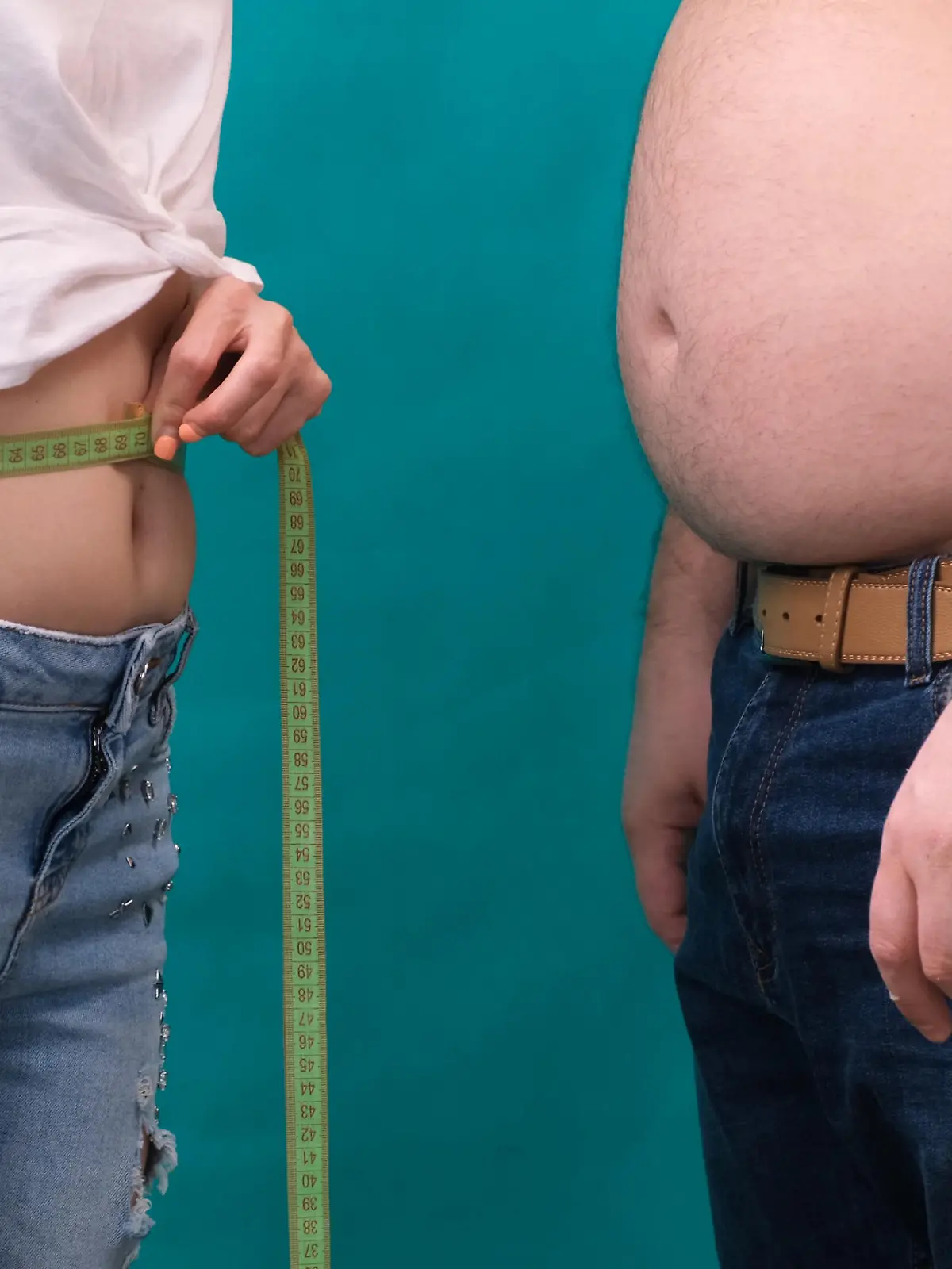 Couple Fat man and thin woman standing together, wrapped in tape measure. Diet, family weight loss and healthcare concept