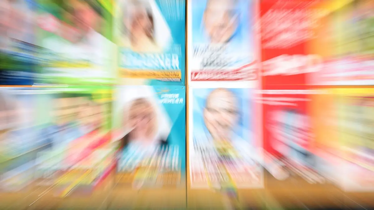 Eine Plakatwand mit Plakaten verschiedener Parteien.