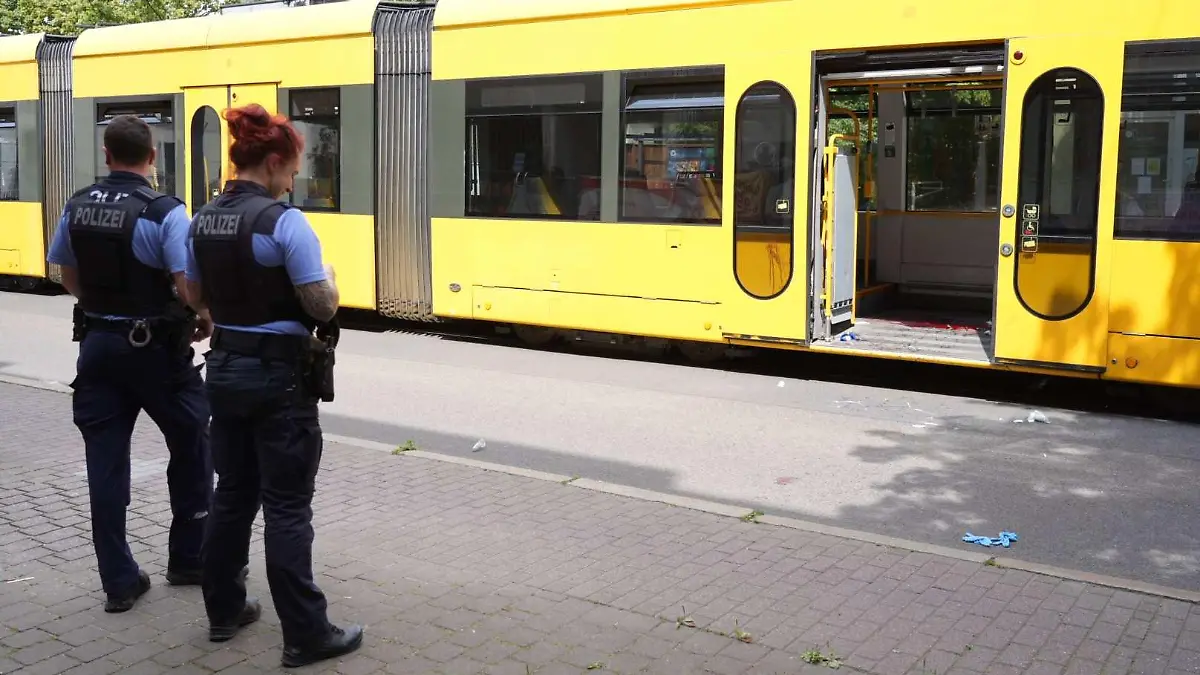 08.07.2023, Sachsen, Dresden: Polizisten stehen vor einer Straßenbahn in der einem Mann schwere Verletzungen mit einem Messer beigebracht worden waren. Der mutmaßliche 32 Jahre alte Täter wurde am Tatort festgenommen. Das Opfer und der Verdächtige sind nach Angaben der Polizei Somalier. Der Hintergrund der tödlichen Attacke ist noch vollkommen unklar. Foto: Benedict Bartsch/xcitepress/dpa +++ dpa-Bildfunk +++