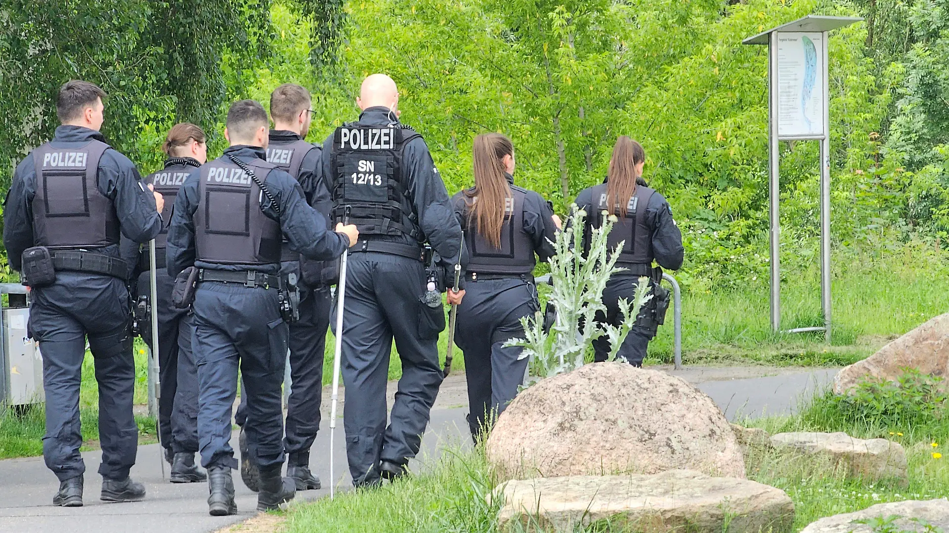 05.06.2024, Sachsen, Döbeln: Polizisten, die an der Suche nach einer Neunjährigen in Döbeln beteiligt sind, gehen über einen Weg. Bei der dringlichen Suche nach dem Mädchen hat die Polizei auch die Bevölkerung zur Mithilfe aufgerufen. Foto: Tobias Junghannß/dpa-Zentralbild/dpa - ACHTUNG: Nur zur redaktionellen Verwendung im Zusammenhang mit der aktuellen Berichterstattung und nur mit vollständiger Nennung des vorstehenden Credits +++ dpa-Bildfunk +++