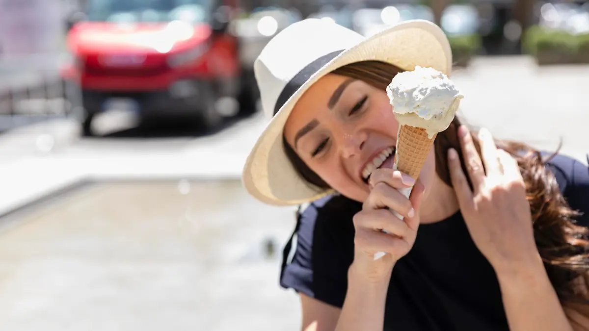 Woman in sun hat licking ice cream || Modellfreigabe vorhanden