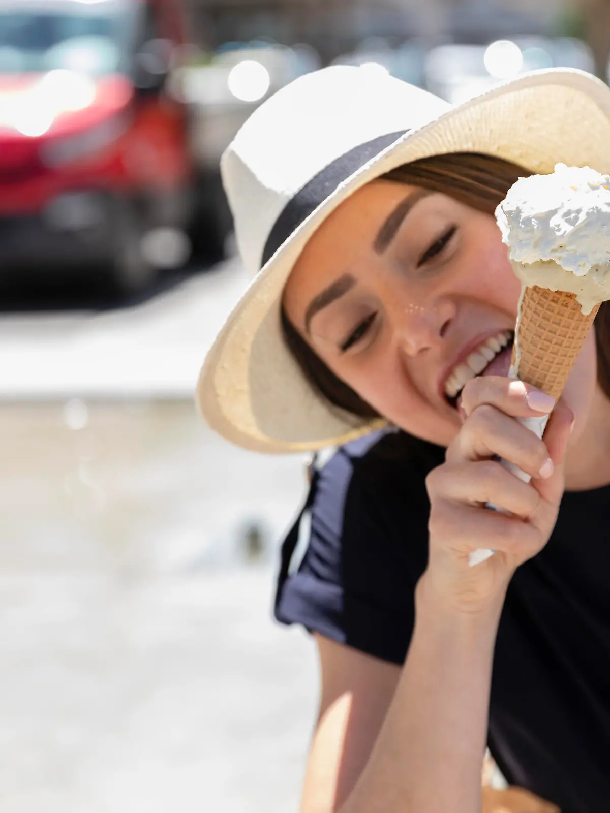 Woman in sun hat licking ice cream || Modellfreigabe vorhanden