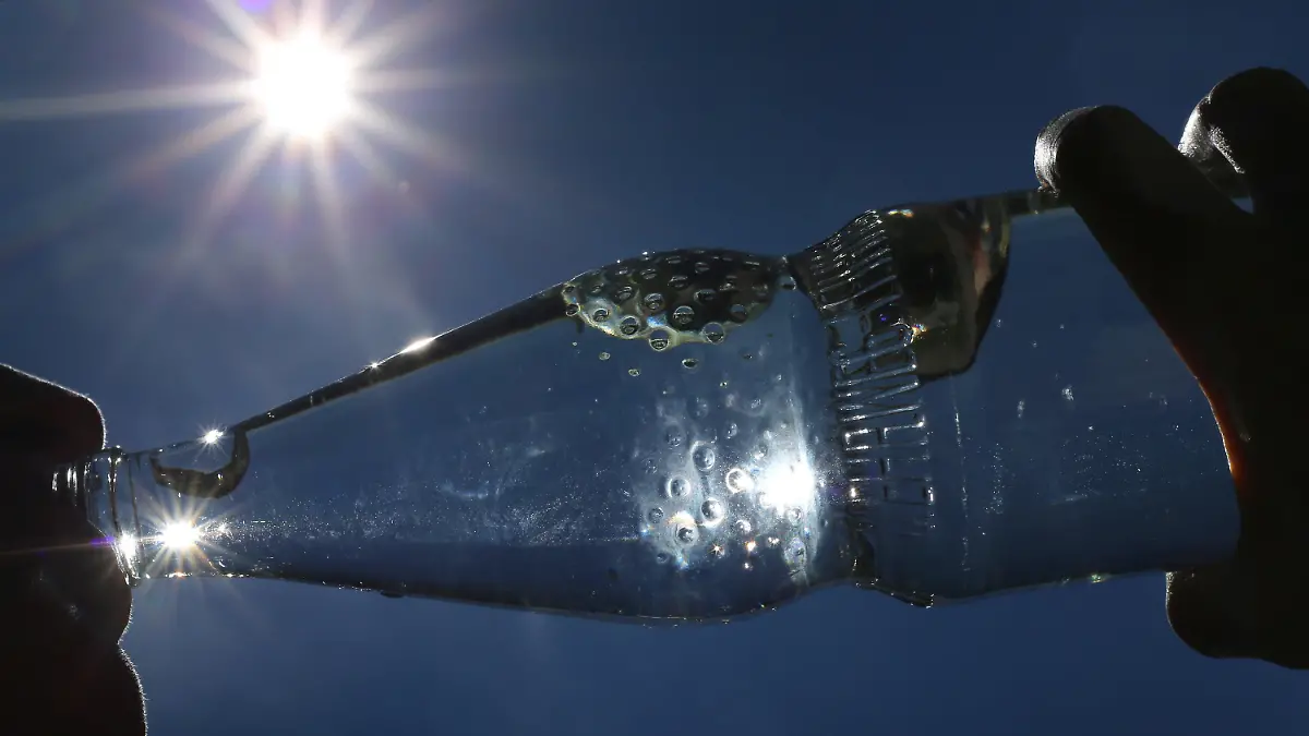ARCHIV - 24.06.2019, Bayern, Kempten: Eine Frau trinkt im Sonnenschein aus einer Flasche sprudelndes Mineralwasser. Draußen ist es richtig heiß - ein kaltes Getränk muss her. Aber ist das eigentlich eine gute Idee? (zu dpa: "Sommer-Fakten gecheckt: Zwischen eiskalter Limo und dunkler Kleidung") Foto: Karl-Josef Hildenbrand/dpa +++ dpa-Bildfunk +++