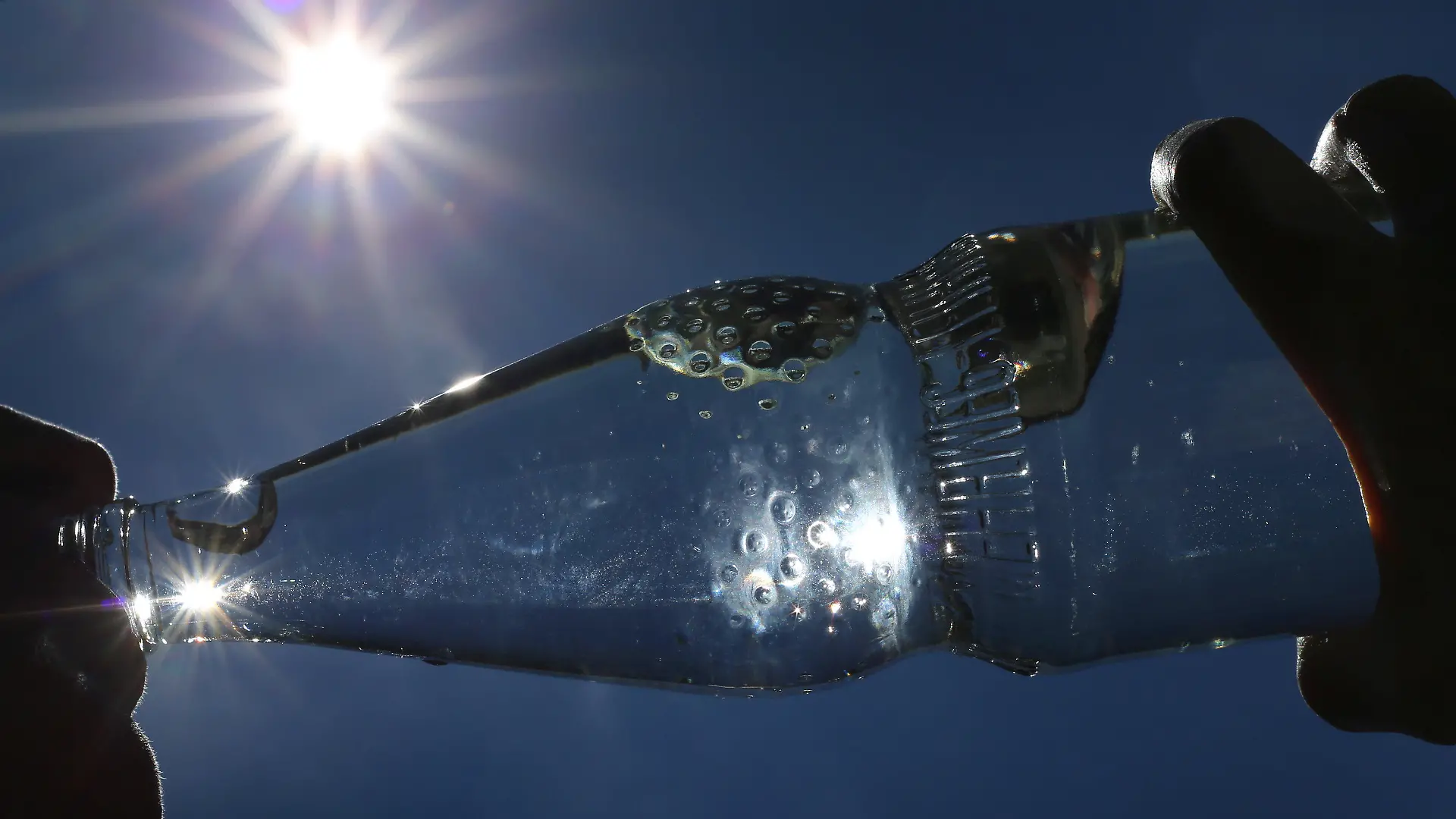 ARCHIV - 24.06.2019, Bayern, Kempten: Eine Frau trinkt im Sonnenschein aus einer Flasche sprudelndes Mineralwasser. Draußen ist es richtig heiß - ein kaltes Getränk muss her. Aber ist das eigentlich eine gute Idee? (zu dpa: "Sommer-Fakten gecheckt: Zwischen eiskalter Limo und dunkler Kleidung") Foto: Karl-Josef Hildenbrand/dpa +++ dpa-Bildfunk +++