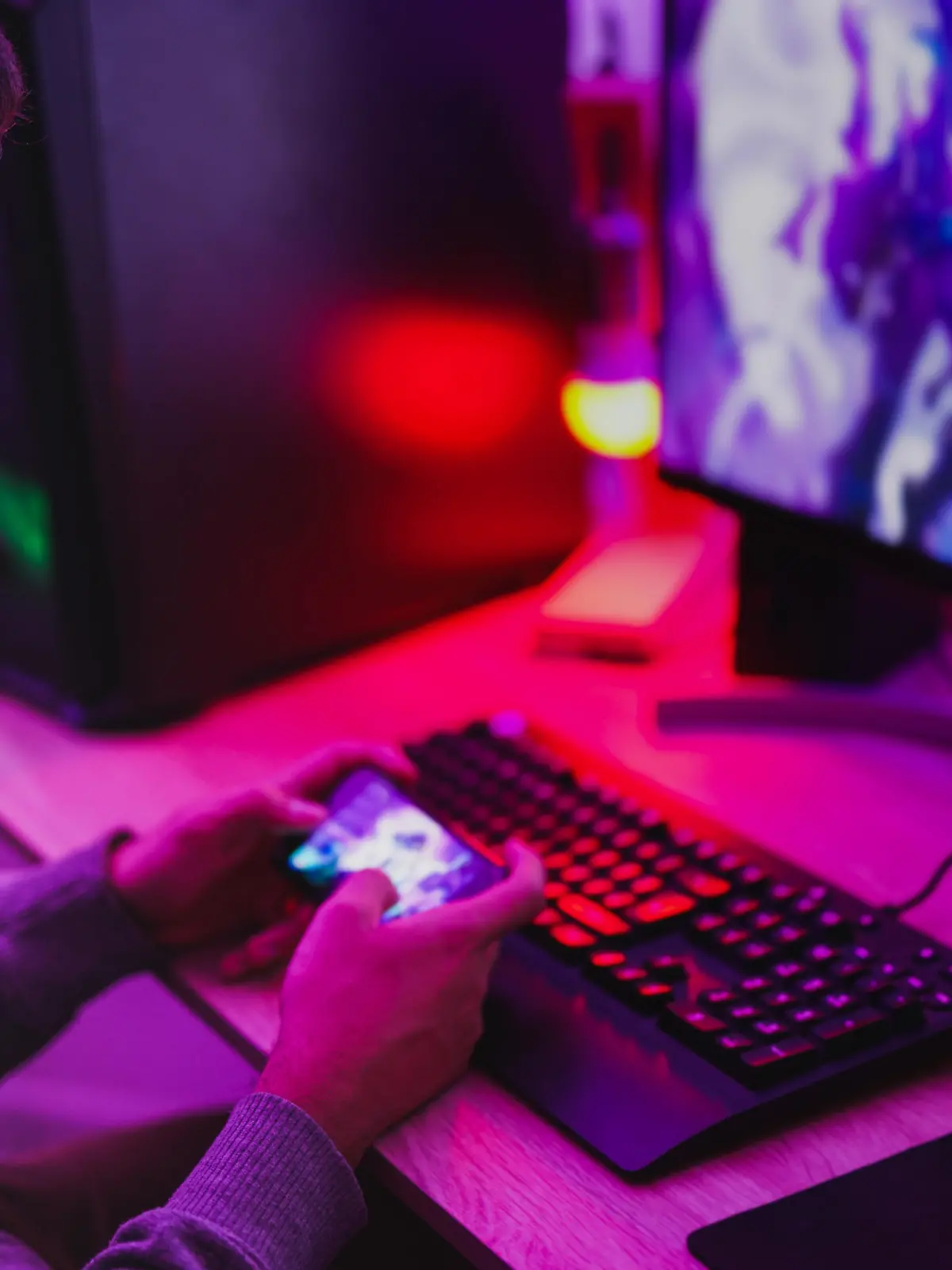 Young boy wearing headset and play video games with smartphone online in front of computer - Home isolated for coronavirus outbreak