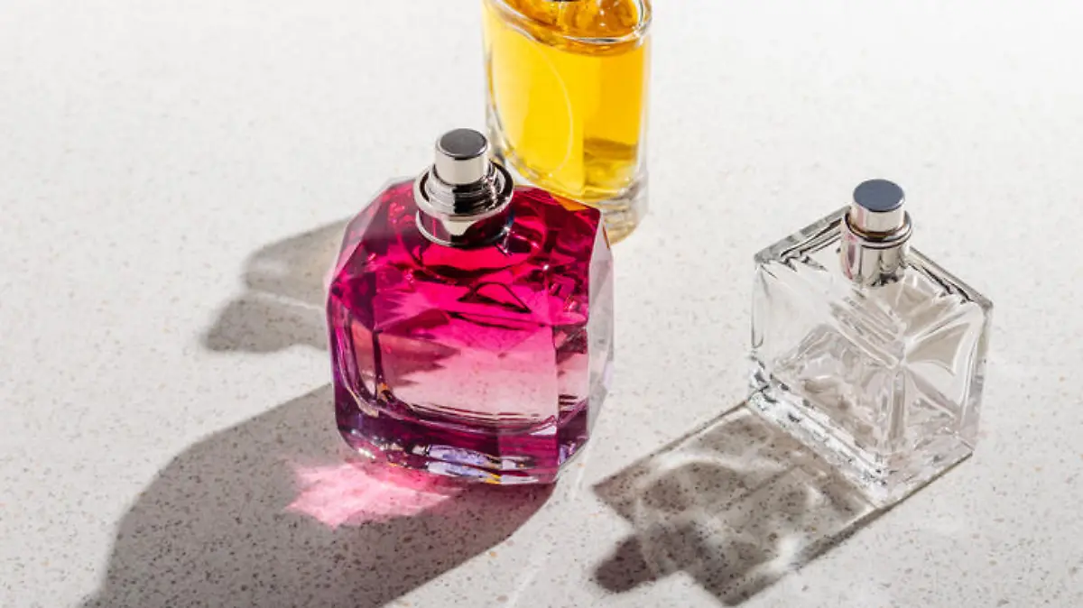 A group of perfume bottles on a white stone background on a sunny day