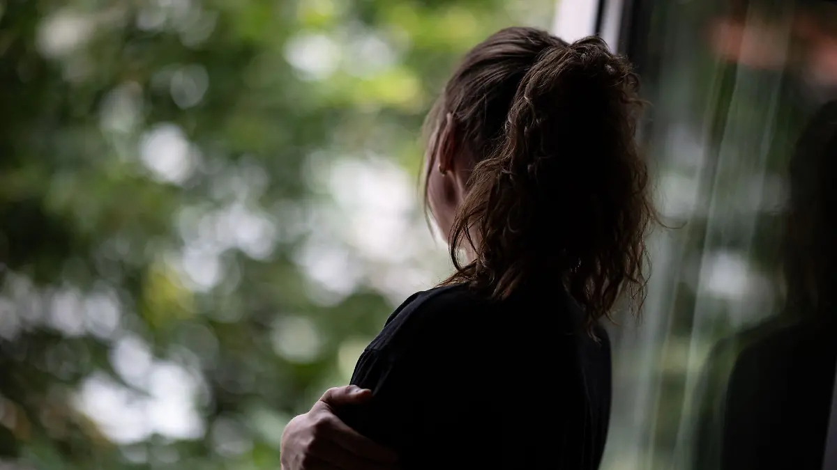 Eine Frau steht am Fenster.
