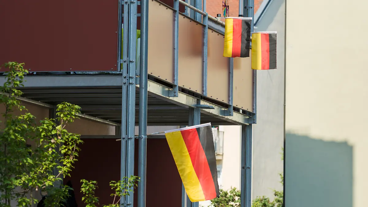 Zwei Balkone sind mit Deutschlandflaggen dekoriert. 