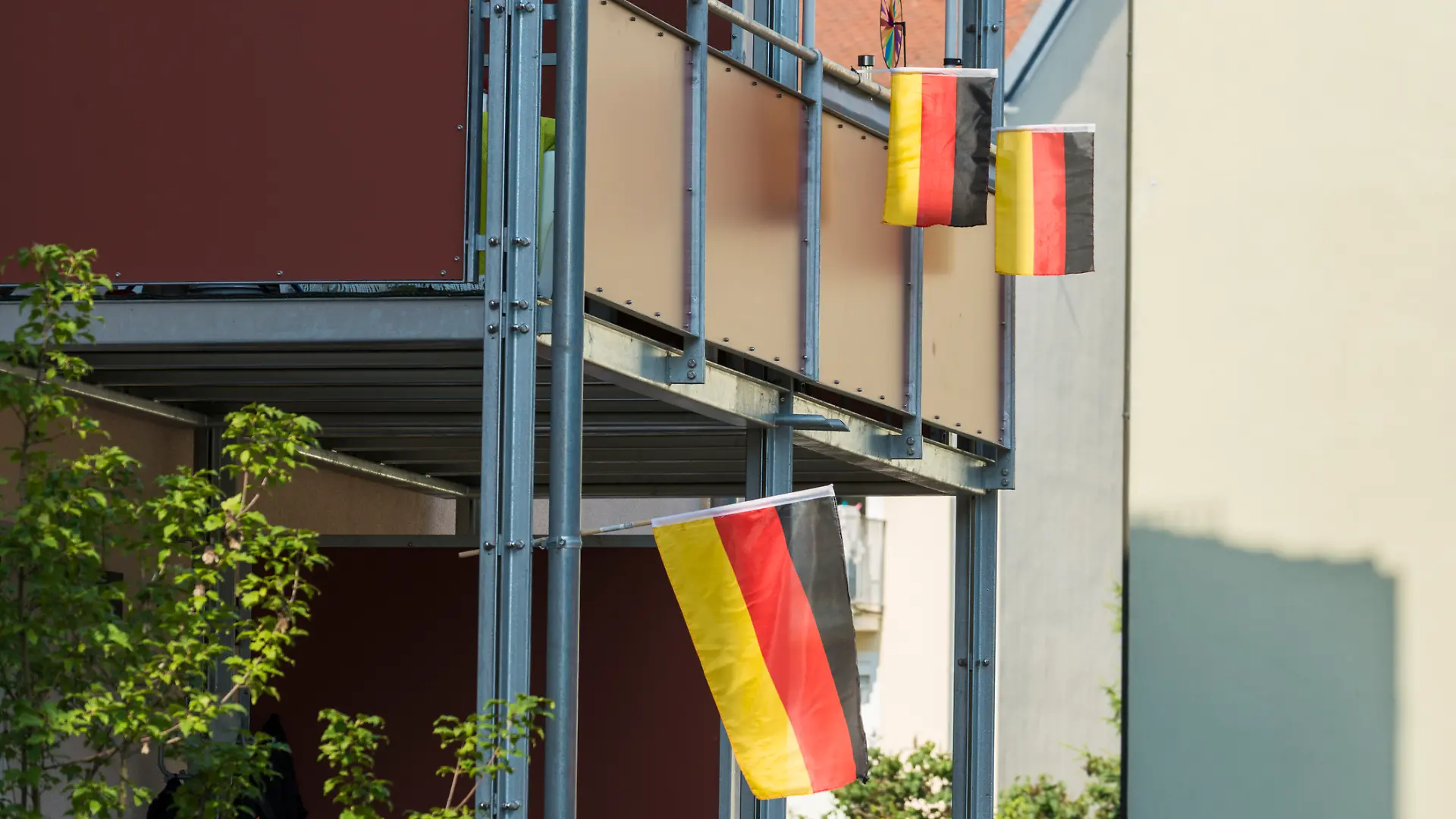 Zwei Balkone sind mit Deutschlandflaggen dekoriert.