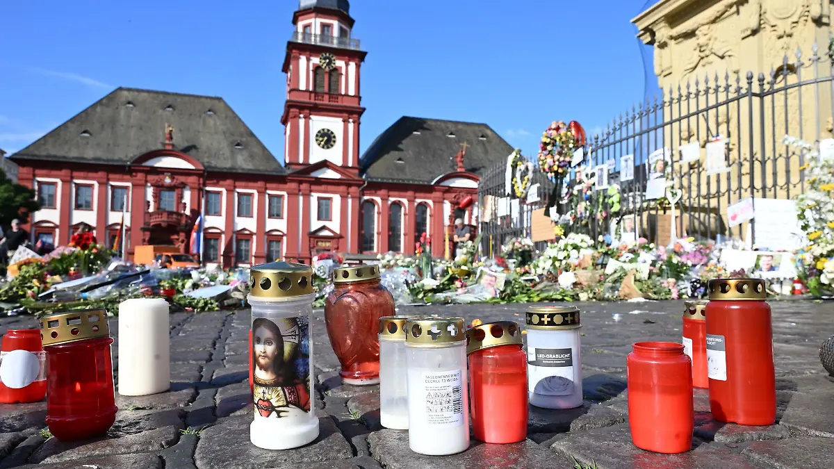 Blumen und Kerzen liegen auf dem Marktplatz in Mannheim zum Gedenken an einen getöteten Polizisten.