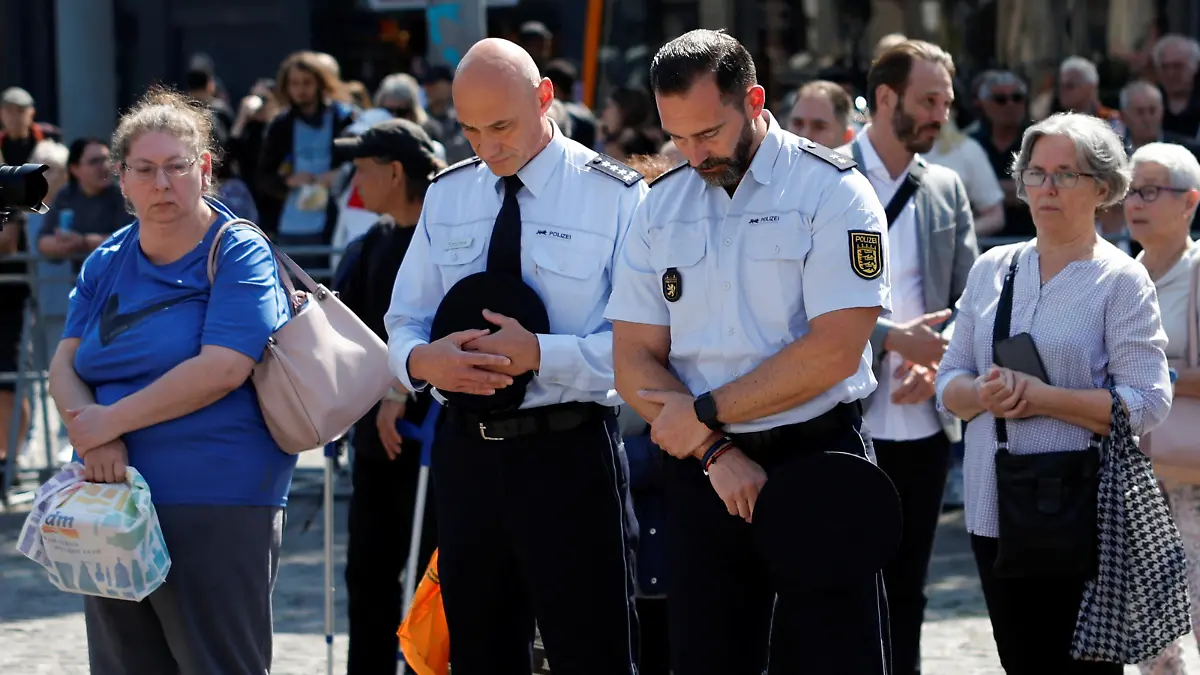 Police officers pay their respects at the site where a man attacked people with a knife at a far right-wing information stand and killed a policeman in the central market of the city of Mannheim, Germany, June 7, 2024. REUTERS/Heiko Becker
