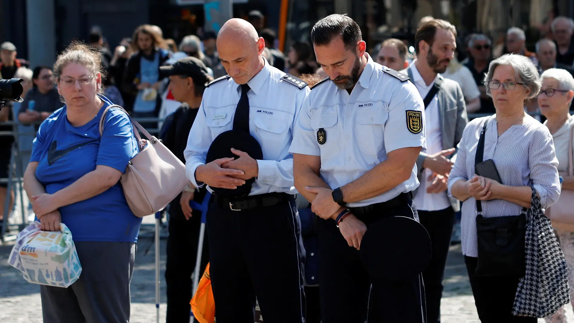 Police officers pay their respects at the site where a man attacked people with a knife at a far right-wing information stand and killed a policeman in the central market of the city of Mannheim, Germany, June 7, 2024. REUTERS/Heiko Becker