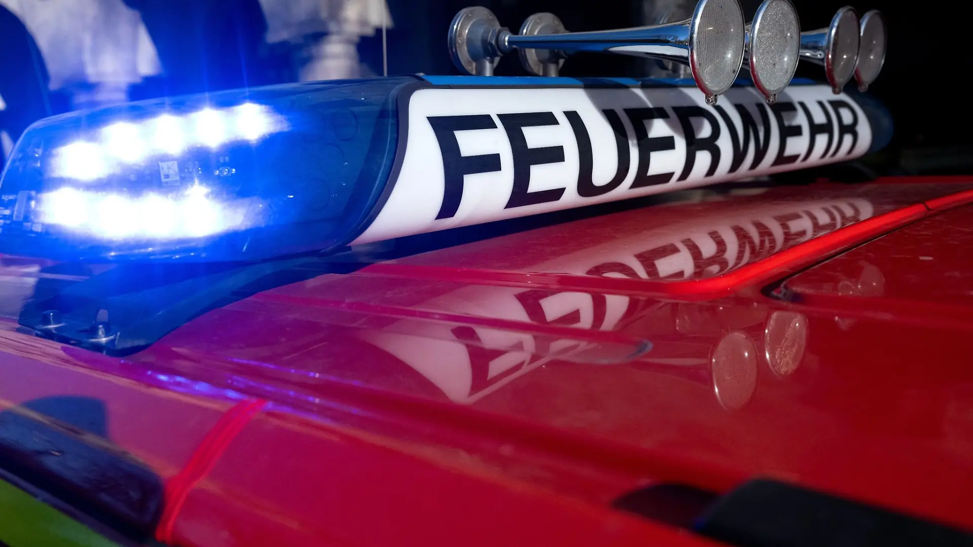 Ein Einsatzfahrzeug der Feuerwehr mit eingeschaltetem Blaulicht.