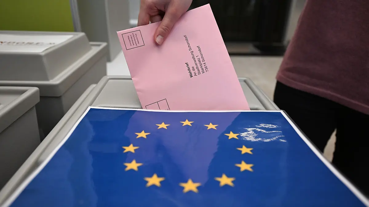 Ein Wahlbrief mit einem Stimmzettel für die Europawahl wird in einem Wahllokal für die Briefwahl in eine Wahlurne gesteckt.