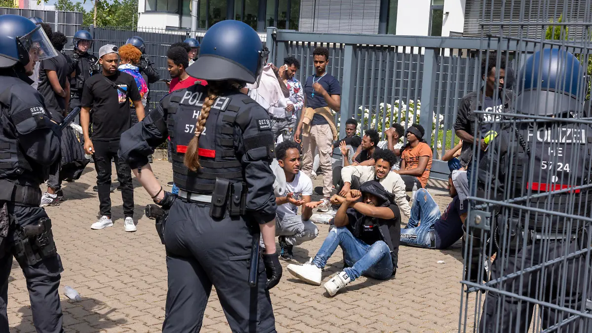 08.07.2023, Hessen, Gießen: Polizisten haben vor Beginn des Eritrea-Festivals in Gießen eine Gruppe von Menschen umringt. Im Zusammenhang mit dem umstrittenen Eritrea-Festival in Gießen hat die Polizei am Samstag Schlagstöcke und Pfefferspray eingesetzt. Mehrere Menschen hätten versucht, eine Polizeikette zu durchbrechen, teilten die Beamten auf Twitter mit. Foto: Helmut Fricke/dpa +++ dpa-Bildfunk +++
