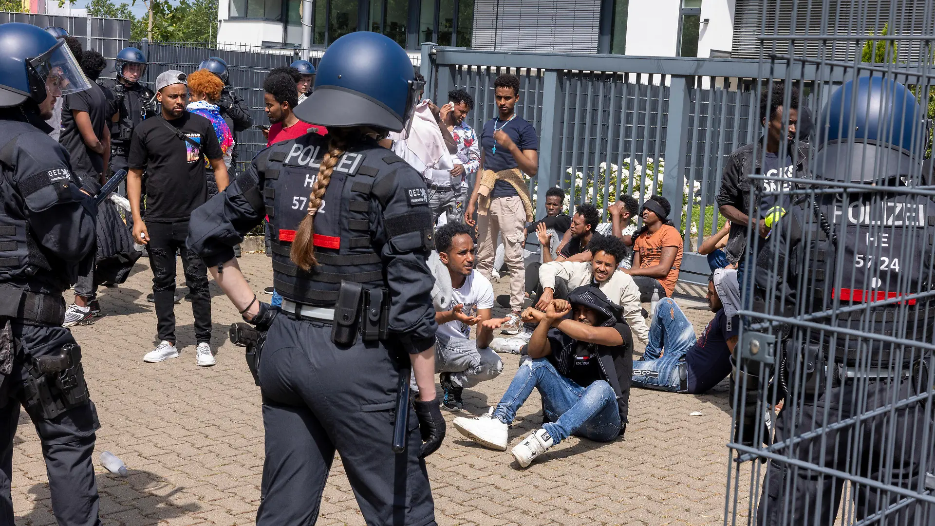 08.07.2023, Hessen, Gießen: Polizisten haben vor Beginn des Eritrea-Festivals in Gießen eine Gruppe von Menschen umringt. Im Zusammenhang mit dem umstrittenen Eritrea-Festival in Gießen hat die Polizei am Samstag Schlagstöcke und Pfefferspray eingesetzt. Mehrere Menschen hätten versucht, eine Polizeikette zu durchbrechen, teilten die Beamten auf Twitter mit. Foto: Helmut Fricke/dpa +++ dpa-Bildfunk +++