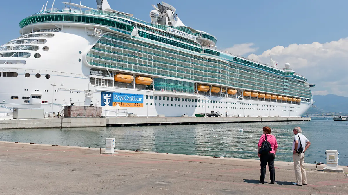 Zwei ältere Menschen stehen vor einem Kreuzfahrtschiff