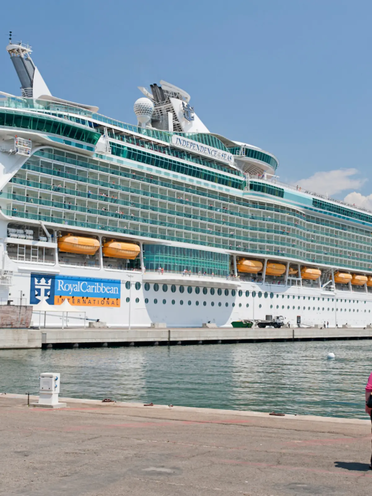 Zwei ältere Menschen stehen vor einem Kreuzfahrtschiff 