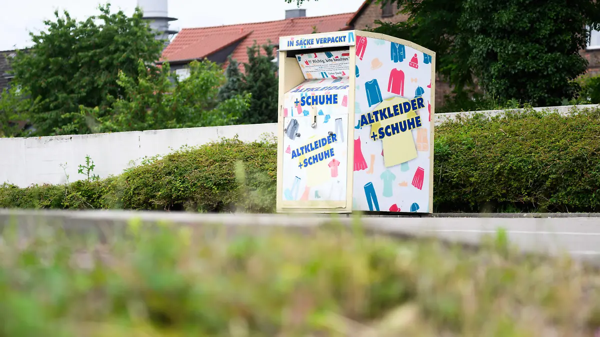 10.06.2024, Niedersachsen, Peine: Ein Altkleidercontainer steht auf einem Supermarkt-Parkplatz. In einem ähnlichen, von der Polizei inzwischen sichergestellten Altkleidercontainer unmittelbar neben diesem Container ist am Sonntagabend eine Frau gestorben. Nach bisherigen Polizeiermittlungen war sie durch die Luke in den Container geklettert und hatte sich dabei den Hals eingeklemmt. Die Polizei schließt nicht aus, dass ein kleines Kind der Frau nun in Gefahr sein könnte. Foto: Julian Stratenschulte/dpa +++ dpa-Bildfunk +++