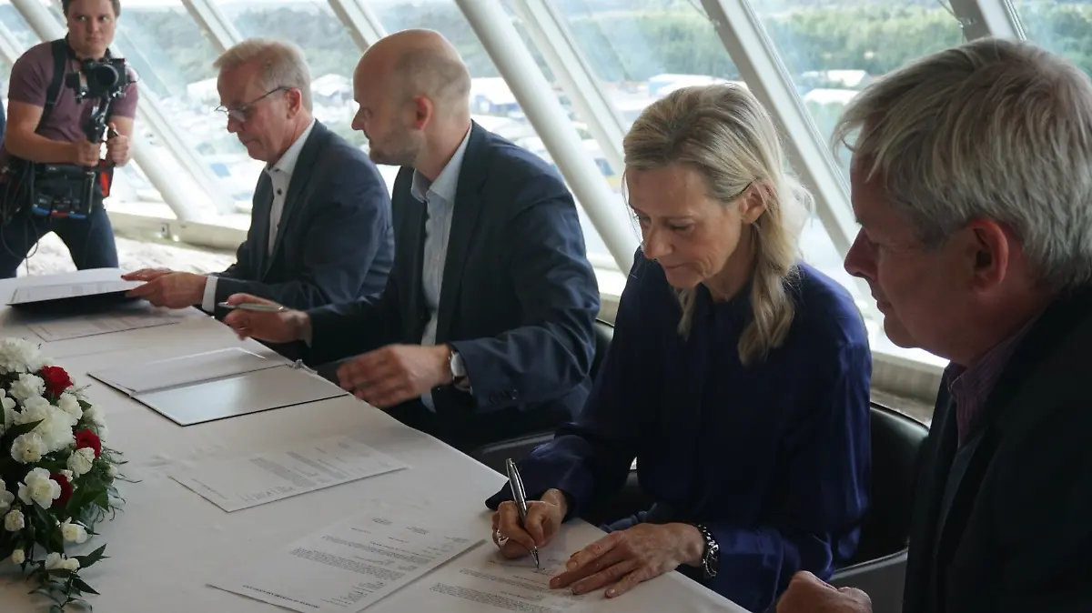 Tui-Cruises-Chefin Wybcke Meier sitzt an einem Tisch in der VIP-Lounge der „Mein Schiff 7” und unterzeichnet das Übergabeprotokoll. Damit besiegelt sie den Kauf des Kreuzfahrtriesen.