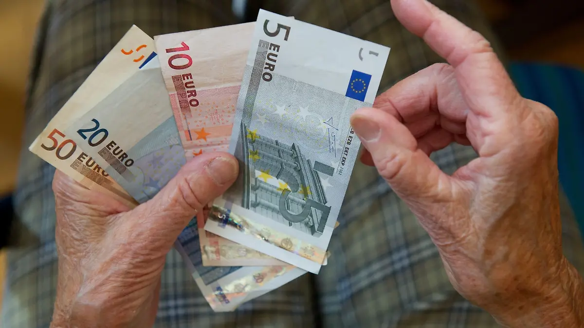 Eine ältere Frau zählt Geld.