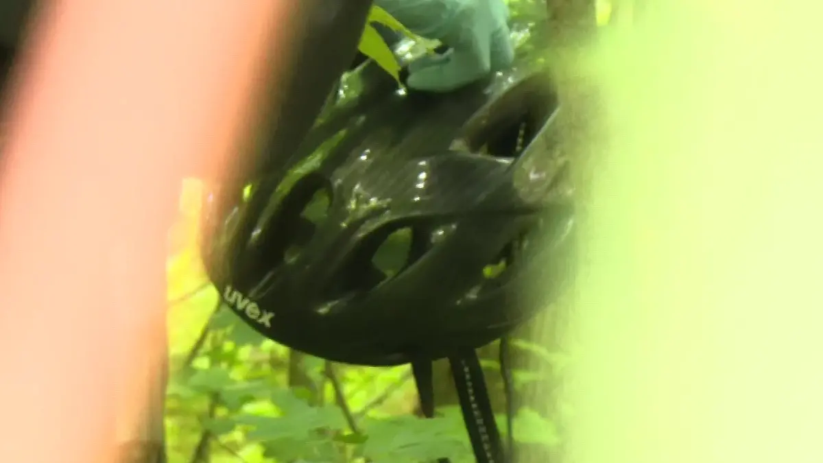 Ein schwarzer Fahrradhelm wird von Polizeibeamten gesichert.