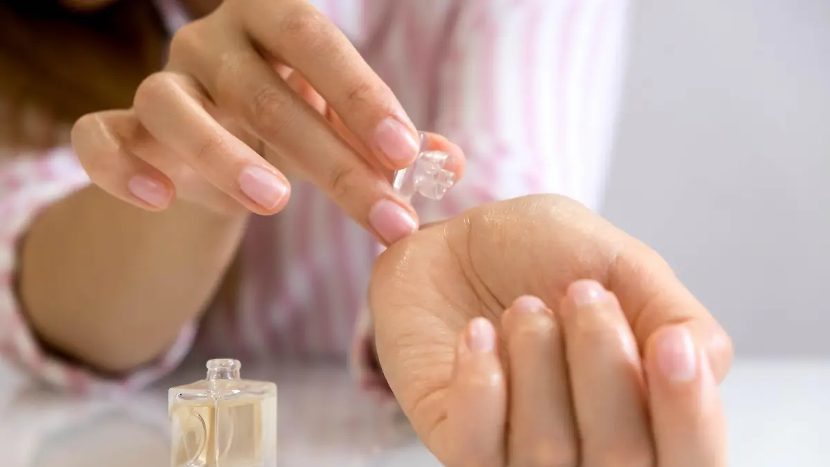 bride applying perfume on her wrist. Elegant woman with perfume. Woman with French manicure applies perfume on her wrist.