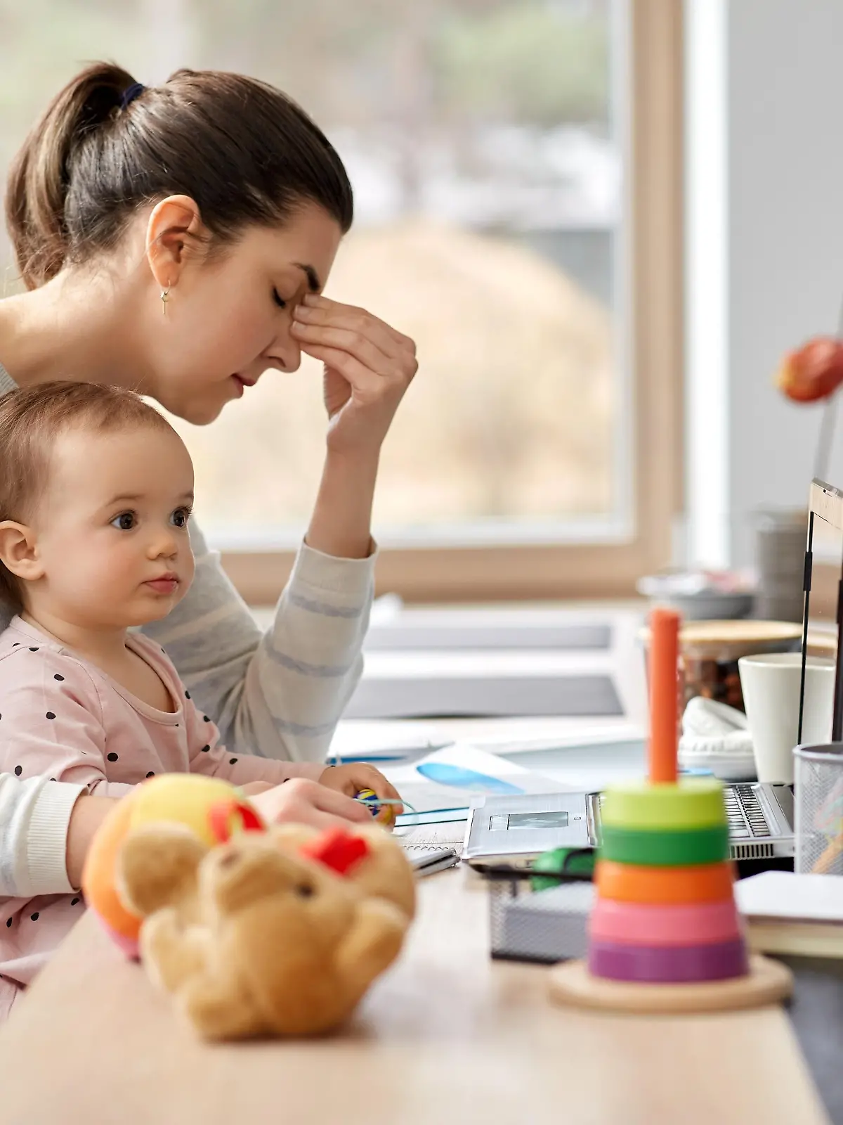 remote job, multi-tasking and family concept - tired mother with baby working at home office
