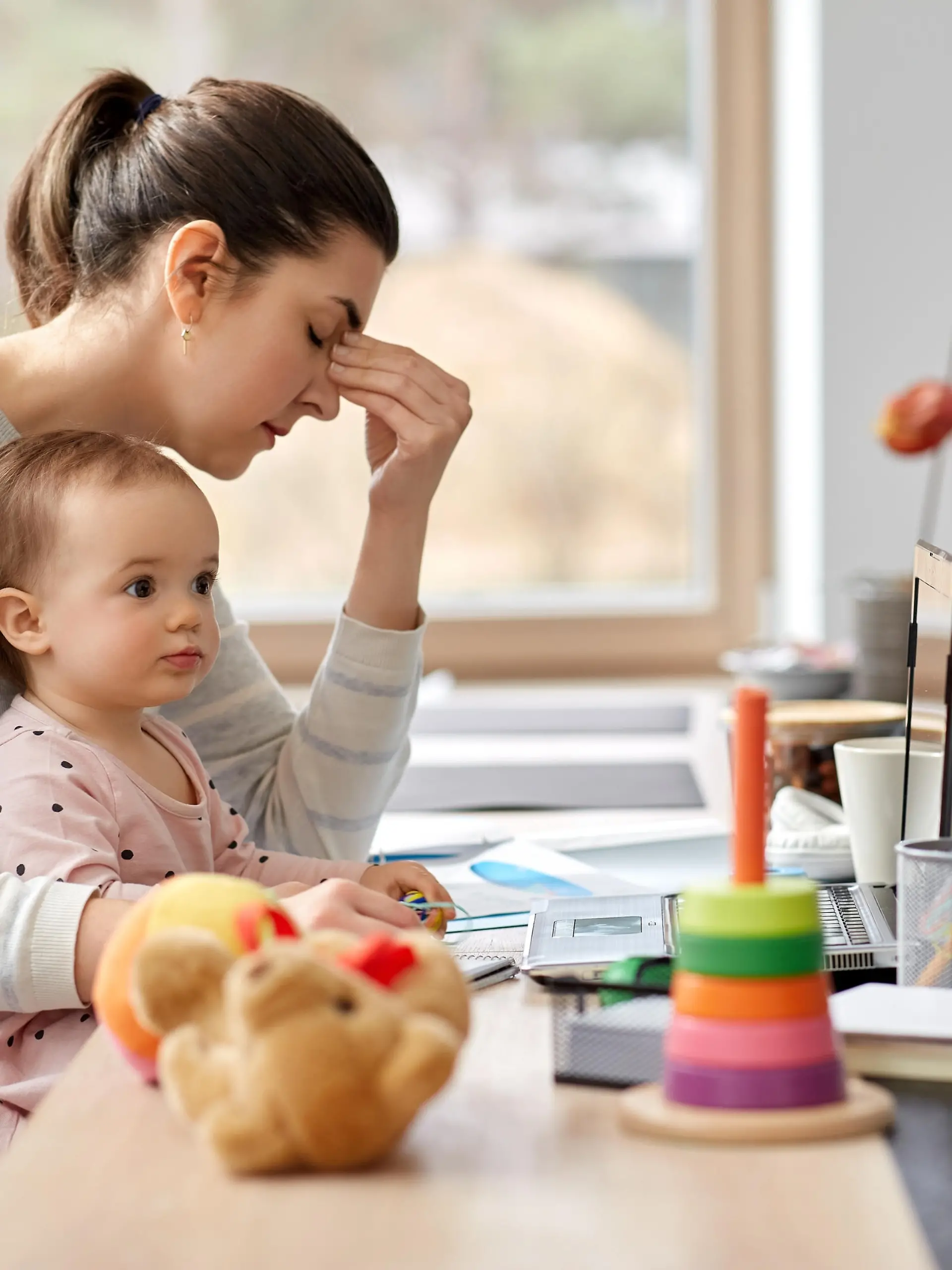 remote job, multi-tasking and family concept - tired mother with baby working at home office
