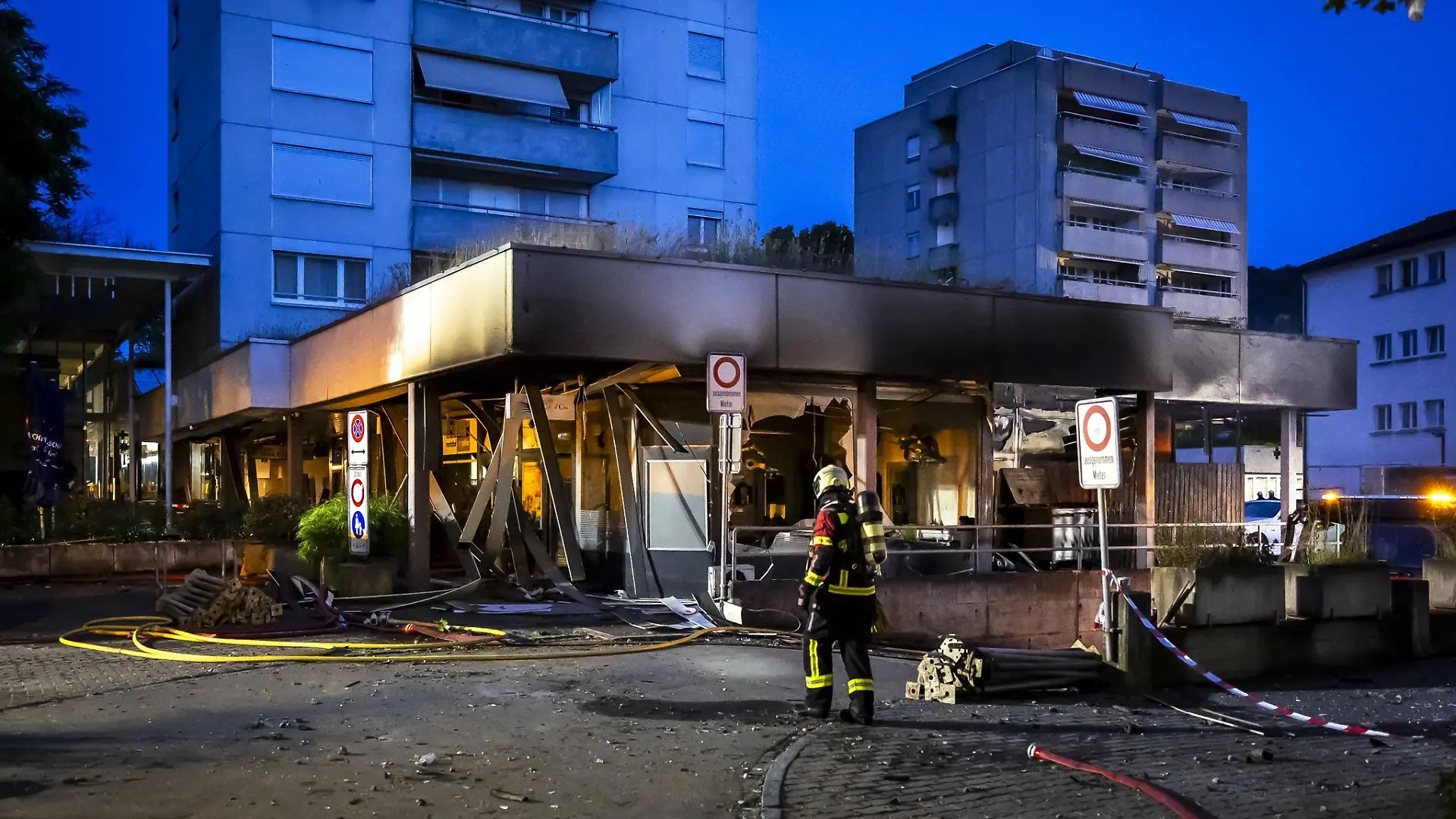 Einsatzkräfte der Feuerwehr am Einsatzort nach einer Explosion in einer Tiefgarage und einem anschliessenden Brand in einem Hochhaus. In Nussbaumen kam es an diesem Donnerstagabend zu Explosionen und einem Brand. Mehrere Gebäude wurden evakuiert. Es wurden mehrere Personen verletzt, zwei Personen verstarben. Der Sachschaden ist erheblich.