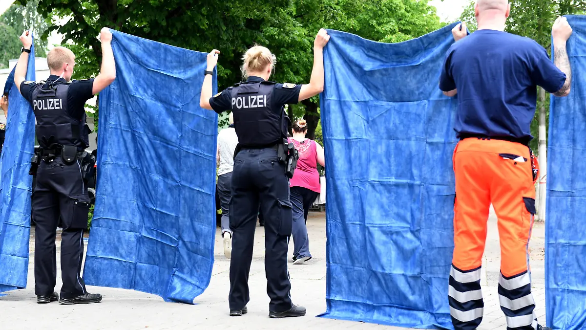 Police officers stand guard as employees of a school where shots were fired, leave the school, in the northern city of Bremerhaven, Germany, May 19, 2022. REUTERS/Fabian Bimmer