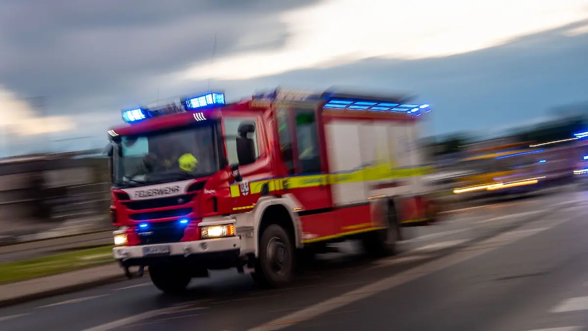 Ein Löschfahrzeug der Feuerwehr fährt mit Blaulicht zu einem Einsatz.