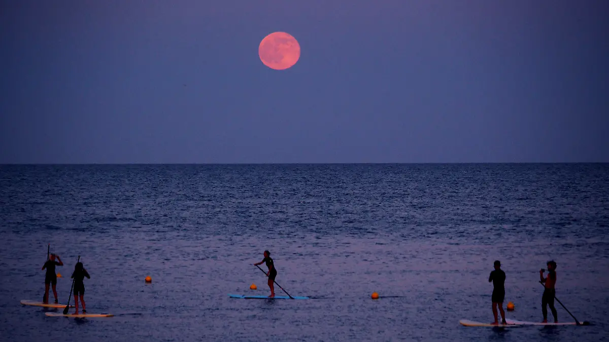 Stand-up-Paddler unter dem Erdbeermond in Barcelona im Jahr 2016.